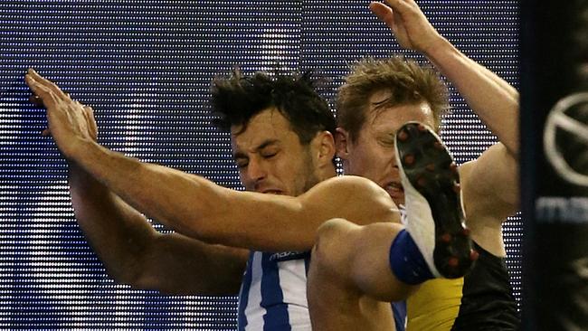 Robbie Tarrant and Jack Riewoldt crash into the fence after a vigorous Riewoldt tackle. Picture: Wayne Ludbey