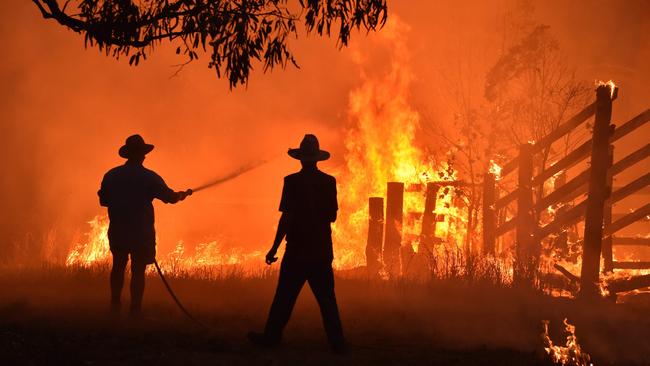 Webb defrauded the bushfire grants scheme set up to help residents like these who defended a property from a bushfire at Hillsville near Taree, 350km north of Sydney on November 12, 2019. Picture: Peter Parks