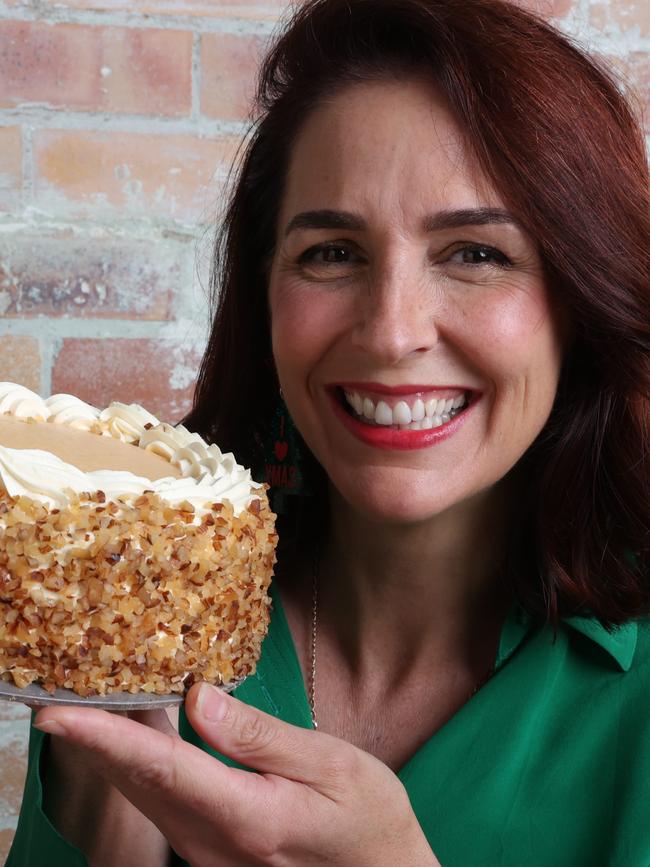 MasterChef finalist Alana Lowes with the Coles Finest Hand Decorated Layered Peach Sponge Cake. Picture: Liam Kidston