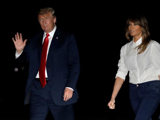 U.S. President Donald Trump waves as he walks with First Lady Melania Trump on the South Lawn of the White House upon their return to Washington, U.S. from Helsinki, Finland, July 16, 2018. REUTERS/Yuri Gripas - RC1596AC19C0