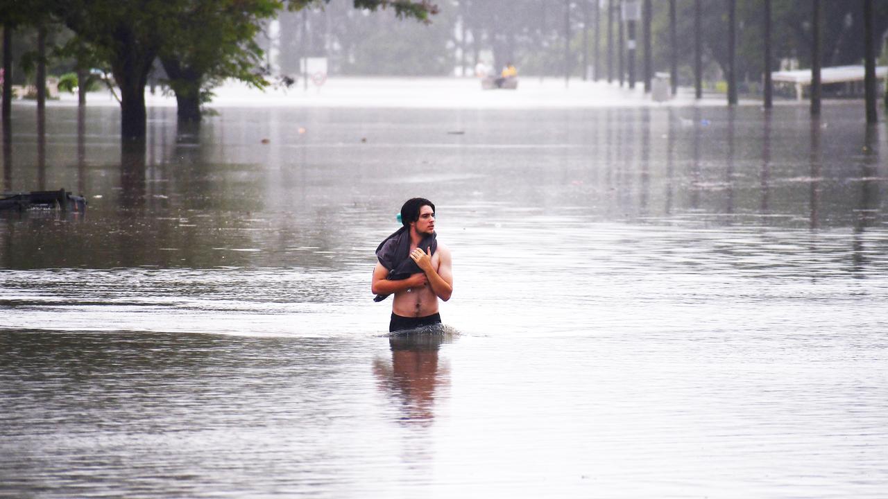 A man walks through Miles St, Ingham on Sunday. Floodwaters inundated most of the town. Picture: Cameron Bates