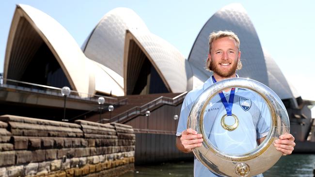 Sydney FC’s grand final goalscorer Rhyan Grant poses with the A-League trophy during a presentation at Sydney Opera House on Monday. Picture: Getty Images