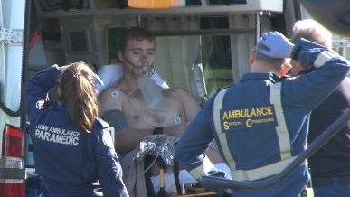 A Royal Australian Navy diver, found unconscious on the bottom of Pittwater, is moved from an ambulance to be placed aboard the CareFlight Rescue helicopter at Porter Reserve, Newport, for the flight to Prince of Wales Hospital at Randwick. Picture: TNV