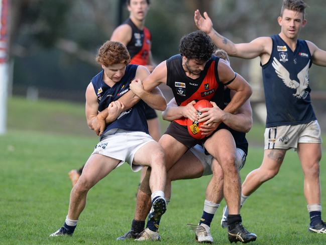 Edithvale-Aspendale players William Flavelle (left) and Matt Clark (obscured) tackle Frankston Bombers player Jason Kingsbury. Picture: Chris Eastman