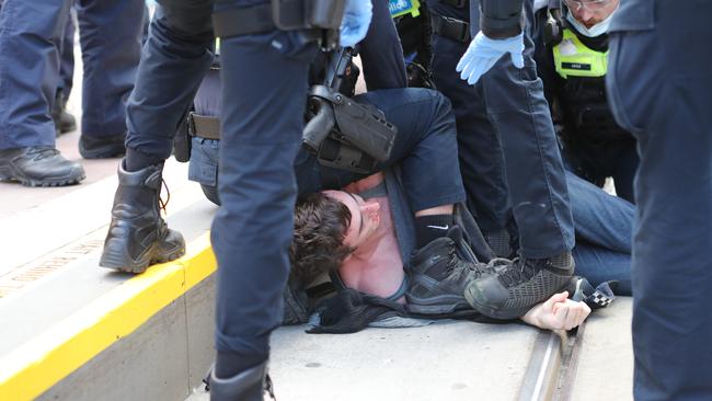 Victoria Police restrain a protester. Picture Rebecca Michael.