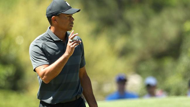 Tiger Woods of the United States waves on the eighth green during the first round of the 2018 Masters Tournament at Augusta National Golf Club.