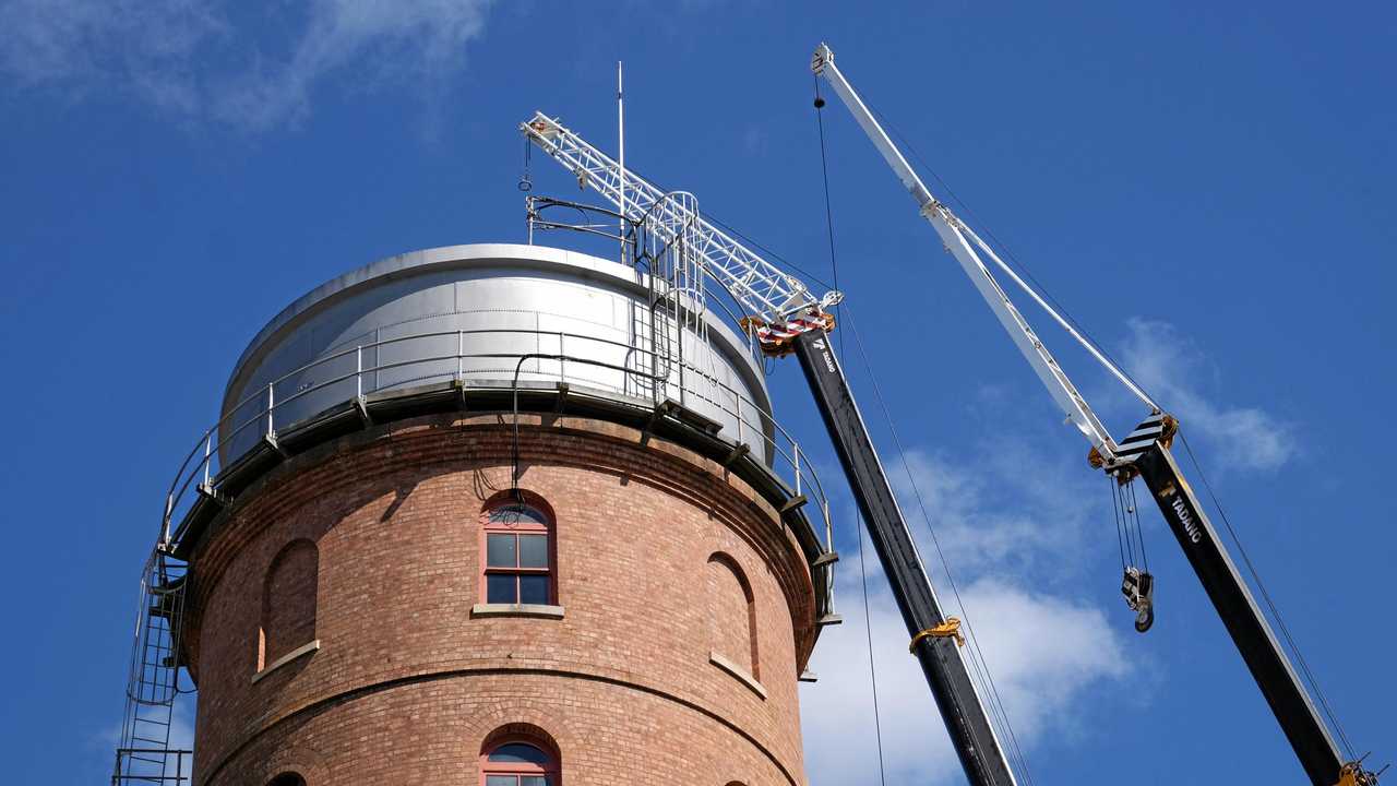 REPAIR JOB: Workers remove the tower roof yesterday. Picture: Mike Knott BUN041018TOWER2