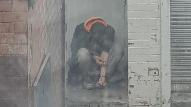 A man injecting himself in the Boyd Lane alleyway way in Dandenong.