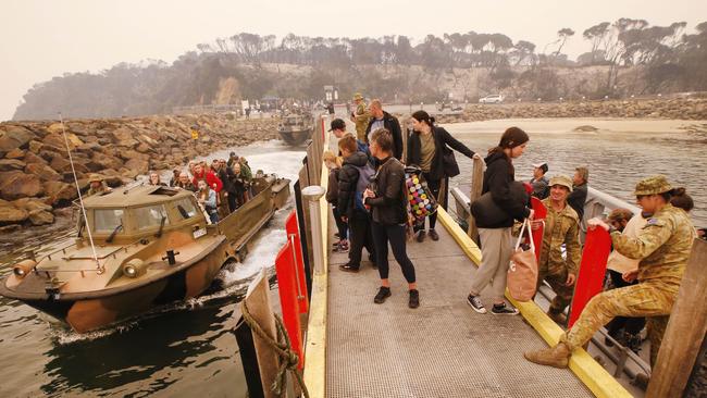 Passengers queue for evacuation from Mallacoota. David Caird