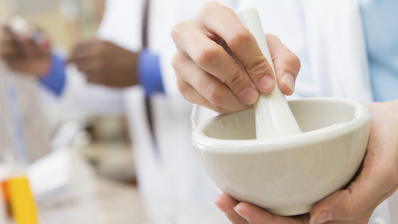 Pharmacist crushing pills to compound prescription medication