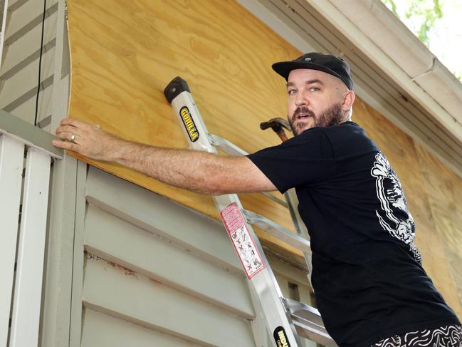 Doug Shobbrook from Redcliffe, using the stateboard ramp plywood to cover windows on the house, people prepping businesses, cafes and houses ahead of Cyclone Alfred, on the Redcliffe peninsular - on Tuesday 4th March 2025 - Photo Steve Pohlner