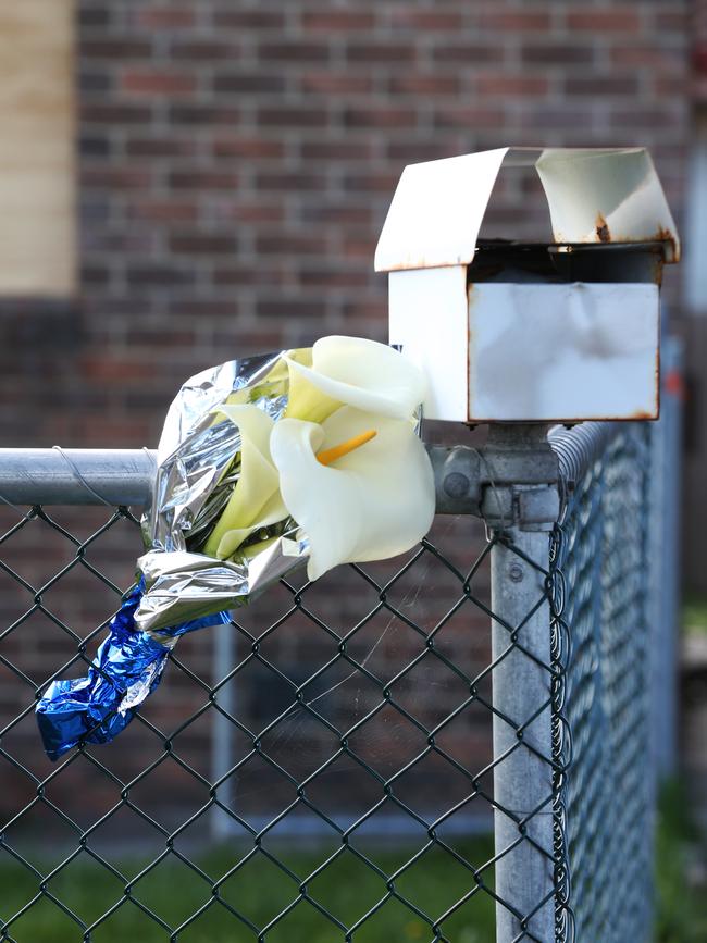 Flowers placed on the fence of the Clarendon Vale unit where Michelle Meades’ body was found.