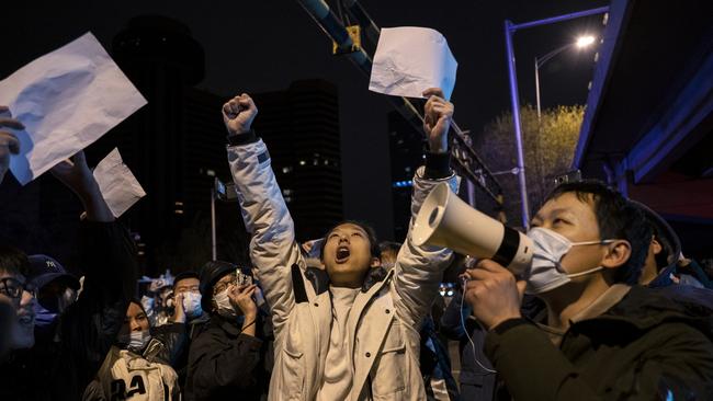 Protesters shout slogans during a protest against China’s strict zero-Covid measures in Beijing on Monday night. Picture: Getty Images