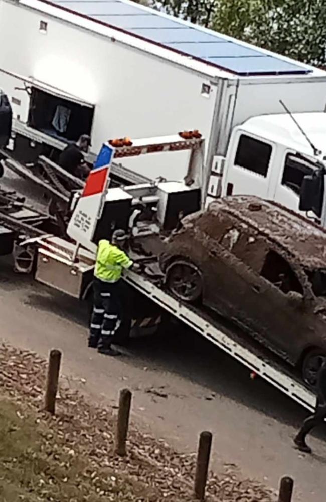 A small SUV is pulled out of the Burnett River under the inner city's main traffic bridge on October 16, 2024.