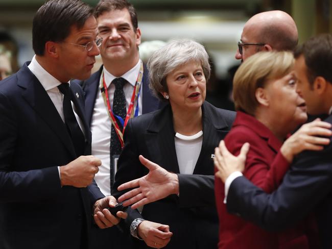 British Prime Minister Theresa May, center, arrives for a round table meeting at an EU summit in Brussels, Thursday, Dec. 13, 2018. EU leaders gathered Thursday for a two-day summit which will center on the Brexit negotiations. At right is French President Emmanuel Macron greeting German Chancellor Angela Merkel. (AP Photo/Alastair Grant)