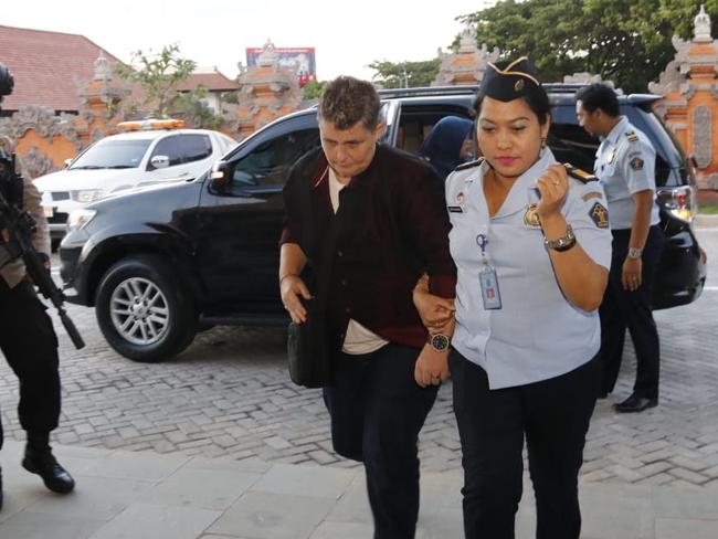 Renae Lawrence is escorted into Bali airport by Immigration officials.