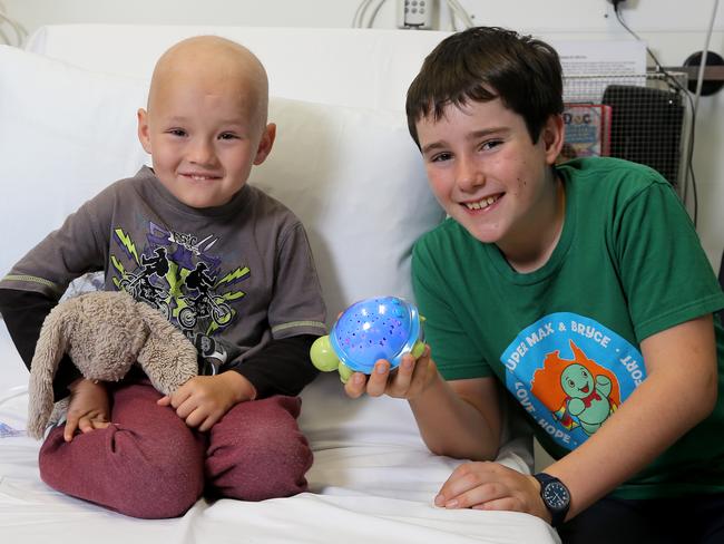 Bryce U’ren, 11, gives a night-light to Tanner Lousic, 4, a cancer patient at Lady Cilento Children's Hospital. Picture AAP/David Clark