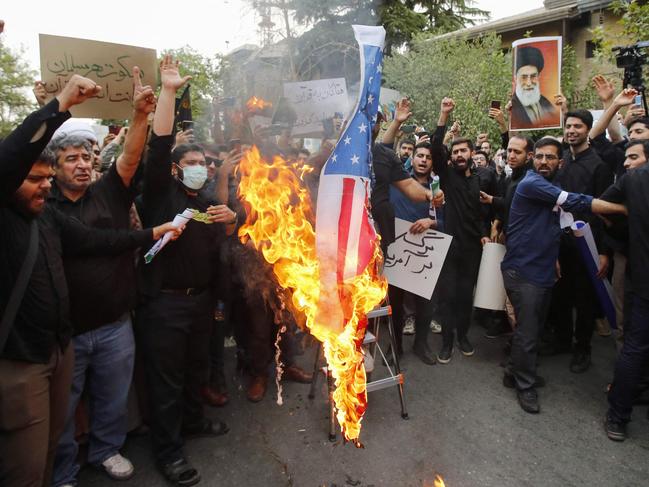 Iranian students burn a US flag during a demonstration denouncing the burning in Sweden of the Koran, Islam's holy book, in front of Swedish embassy in Tehran on July 21, 2023. Demonstrators marched in the Iraqi and Iranian capitals on July 21 to denounce Sweden's permission for protests that desecrate the Koran, as Stockholm withdrew staff from its Baghdad embassy. (Photo by AFP)