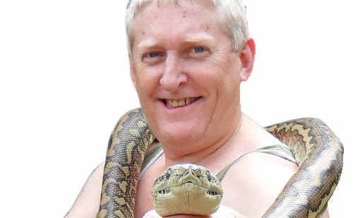 Mark Redwood keeps a firm hold on one of the two female pythons found in his garage roof. Picture: Contributed