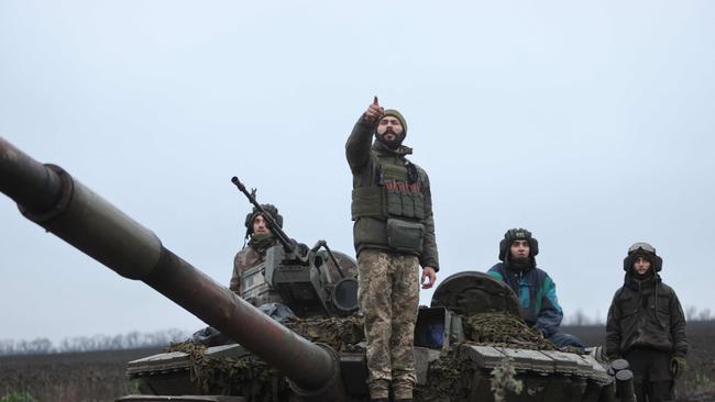 Ukrainian soldiers stand atop their tank in a field near an undisclosed frontline position in eastern Ukraine on November 28.