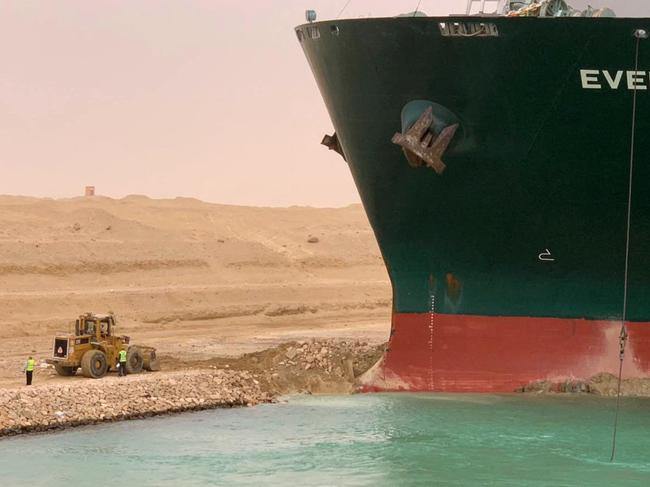 CORRECTION / A handout picture released by the Suez Canal Authority on March 24, 2021 shows a part of the Taiwan-owned MV Ever Given (Evergreen), a 400-metre- (1,300-foot-)long and 59-metre wide vessel, lodged sideways and impeding all traffic across the waterway of Egypt's Suez Canal. - A giant container ship ran aground in the Suez Canal after a gust of wind blew it off course, the vessel's operator said on March 24, 2021, bringing marine traffic to a halt along one of the world's busiest trade routes. (Photo by - / Suez CANAL / AFP) / âThe erroneous mention[s] appearing in the metadata of this photo by Marina PASSOS has been modified in AFP systems in the following manner: [STR] instead of [Marina Passos]. Please immediately remove the erroneous mention[s] from all your online services and delete it (them) from your servers. If you have been authorized by AFP to distribute it (them) to third parties, please ensure that the same actions are carried out by them. Failure to promptly comply with these instructions will entail liability on your part for any continued or post notification usage. Therefore we thank you very much for all your attention and prompt action. We are sorry for the inconvenience this notification may cause and remain at your disposal for any further information you may require.â