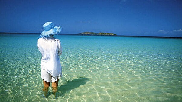 A tourist wading in water at Pumpkin Island off the coast at Yeppoon.