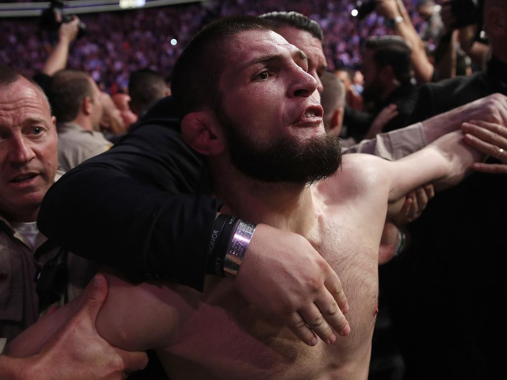 Khabib Nurmagomedov is held back outside of the cage. (AP Photo/John Locher)