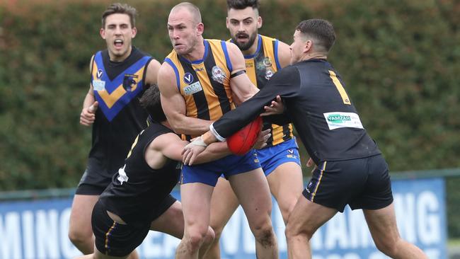 St Bernard’s Nick Cooke is put under pressure by two Old Carey opponents. Picture: David Crosling