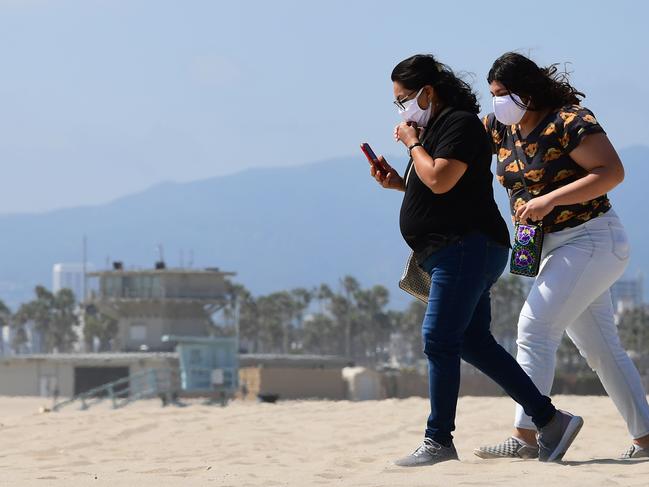 Two women wear face masks at Venice Beach as California reopened beaches with conditions. Picture: AFP