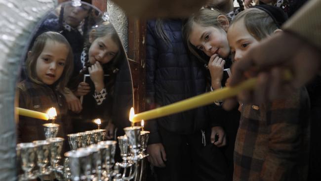 The Ultra-Orthodox Krois family light candles on the first night of the Jewish holiday of Hanukkah in Jerusalem on Sunday. Picture: AFP