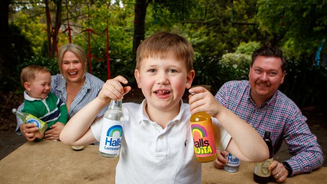 Adelaide businessman Cameron and Tahlia Ballard with their children Walter, 2 and Albert, 6 with some of the mock-up Halls labels. Picture Matt Turner.