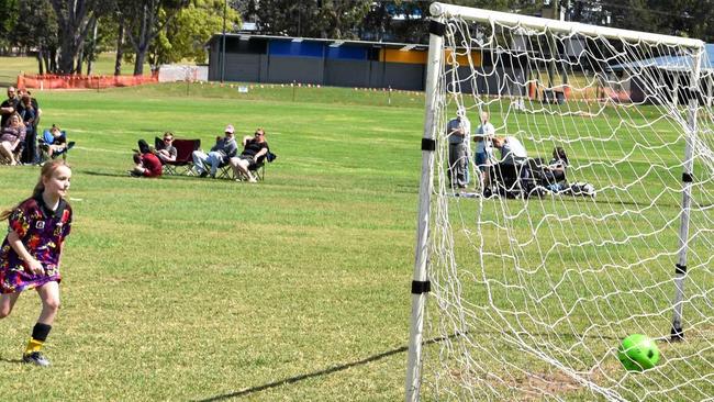 SCORE: A young player in the Under 12 Girls competition follows through after kicking the ball into the goal. Picture: Arthur Gorrie