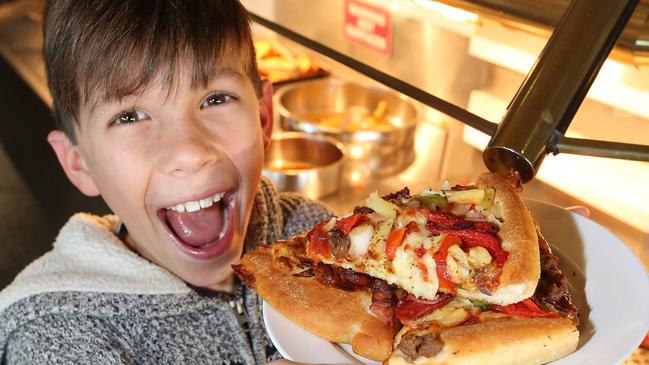 Last day of operations at Pizza Hut in Kirra. Ten-year-old Deshan Schokman enjoys a feed. Picture: Mike Batterham.