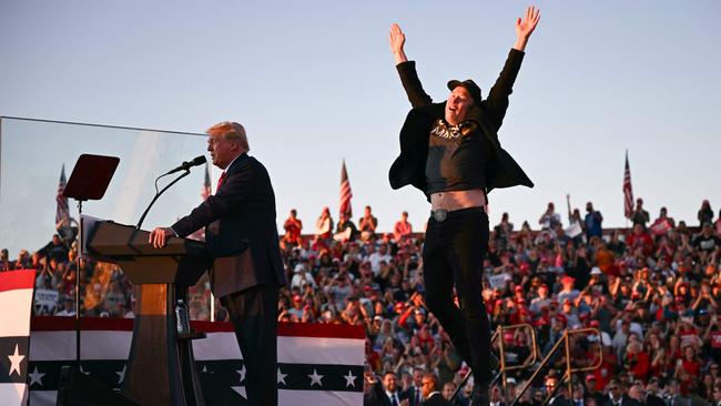 Tesla and SpaceX chief executive Elon Musk jumps on stage as he joins Donald Trump during a campaign rally.