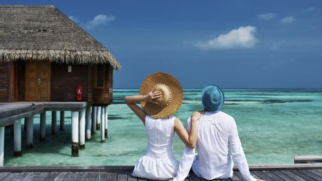 Couple on a tropical beach jetty at Maldives