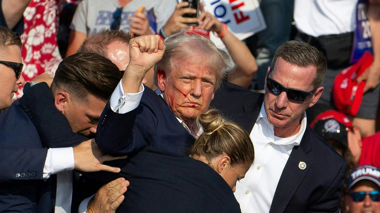 Republican candidate Donald Trump is surrounded by secret service agents who take him off the stage at a campaign event in Butler, Pennsylvania. Picture: Rebecca Droke/AFP