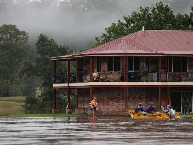 A State Emergency Service rescue crew evacuates a person by boat after rising floodwaters trapped residents, as the state of New South Wales experiences widespread flooding and severe weather, in western Sydney, Australia, March 23, 2021.  REUTERS/Loren Elliott/Pool