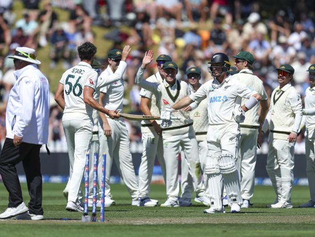 NZ’s Will Young is handed his bat by Mitchell Starc after the wicket of Kane Williamson. Picture: Getty Images