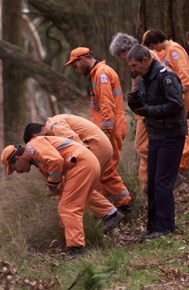 SES volunteers and police search the scrubland scene.