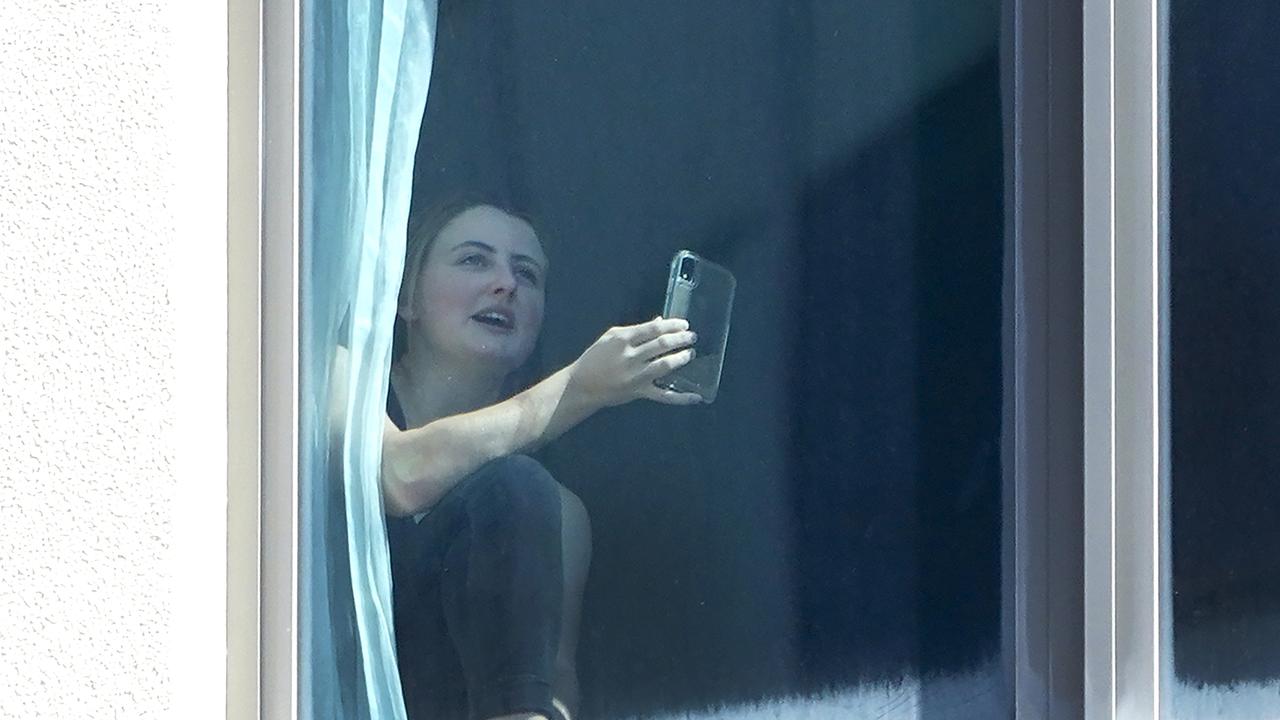 A quarantined traveller looks on from the Voco Hotel in Surfers Paradise on Monday. Picture: Dave Hunt/AAP