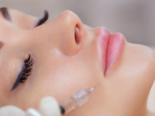 The doctor cosmetologist makes Lip augmentation procedure of a beautiful woman in a beauty salon.Cosmetology skin care.