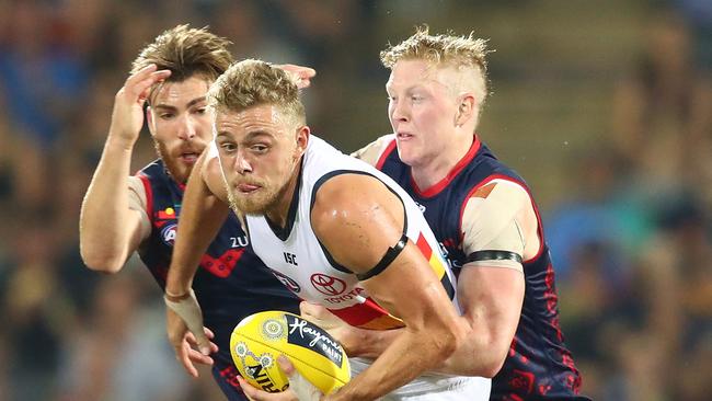 Hugh Greenwood crashes past Demons pair Clayton Oliver and Jack Viney. Picture: Scott Barbour/Getty Images