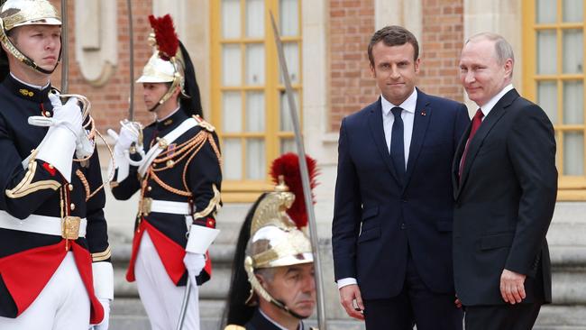 Russian President Vladimir Putin (R) is welcomed by French President Emmanuel Macron (L) at the Versailles Palace, in 2017.