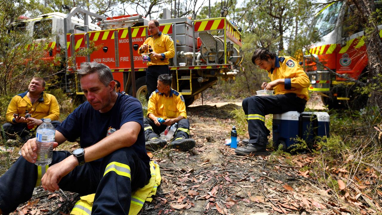 RFS firefighter Wayne Everett (front) and the Cherrybrook RFS crew take a break for Christmas lunch during an effort to clear containment lines in bushland in the Blue Mountains. Picture: Sam Mooy