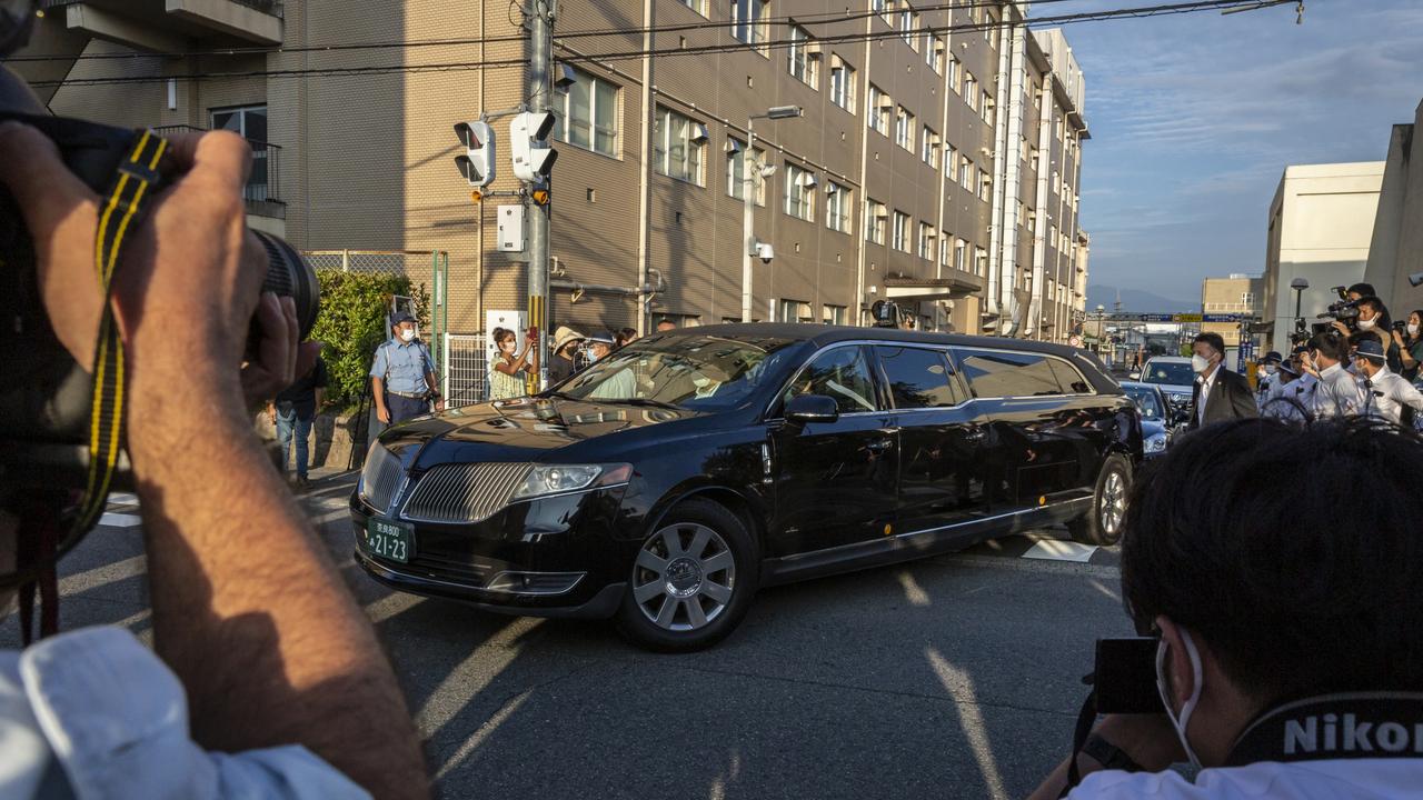 Media photograph the hearse leaving Nara Medical University Hospital with the body of Shinzo Abe with the former leader’s wife inside. Picture: Getty