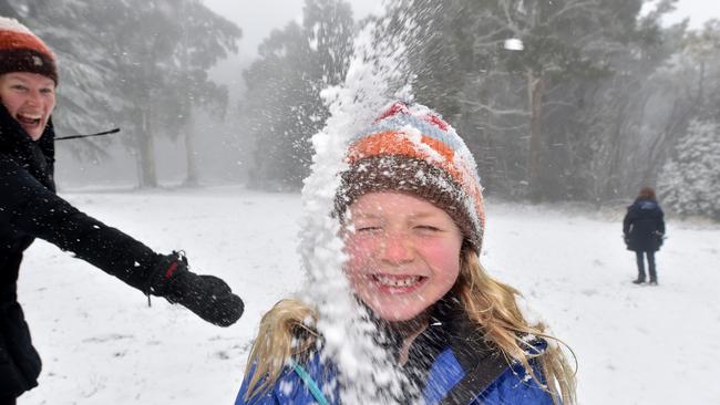 Rose, 6, from Woodend cops an earful of snow from mum, Clare, at Mt Macedon. Picture: Jay Town