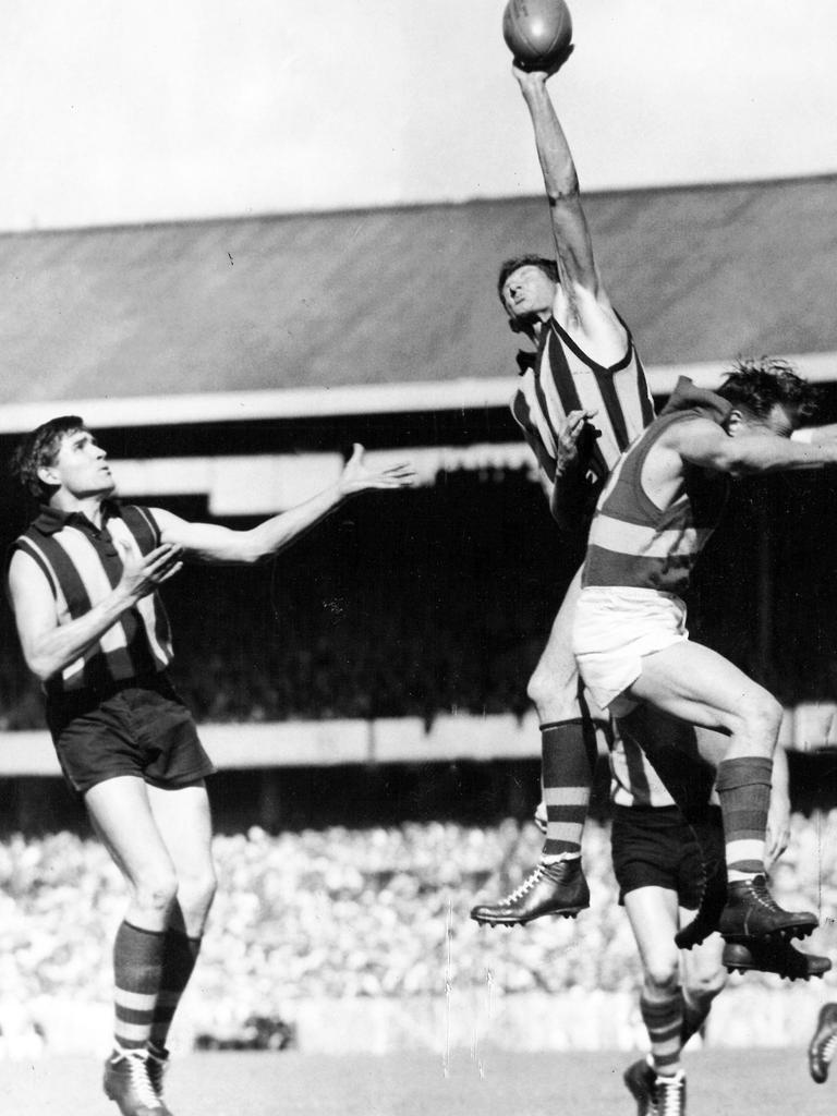 Hawthorn won the 1961 grand final against Footscray. Hawk John Winneke is pictured soaring above Footscray’s Ted Whitten to grab the ball.