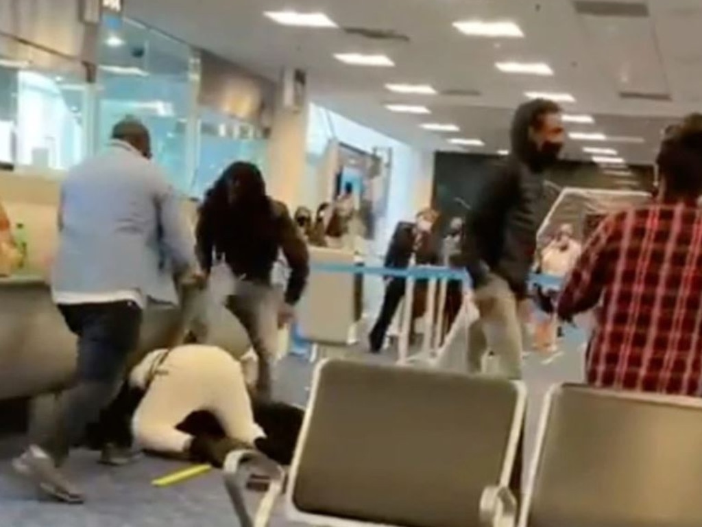 Two people involved in the brawl can be seen viciously kicking another person on the ground.