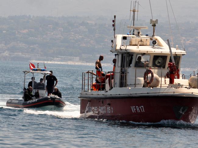 Divers of the Vigili del Fuoco return to the shore with Hannah Lynch’s body. Picture: AFP