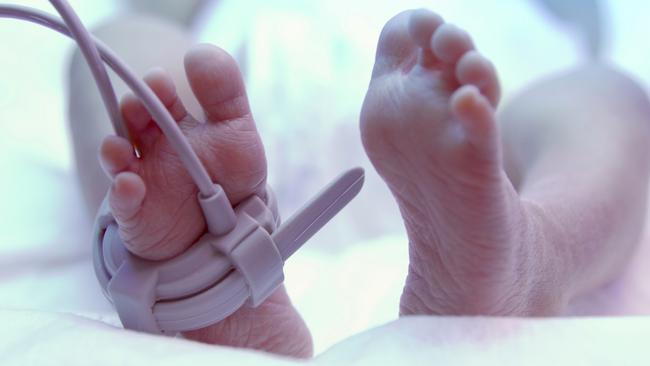 Feet of new born baby under ultraviolet lamp in the incubator. iStock Image – Generic